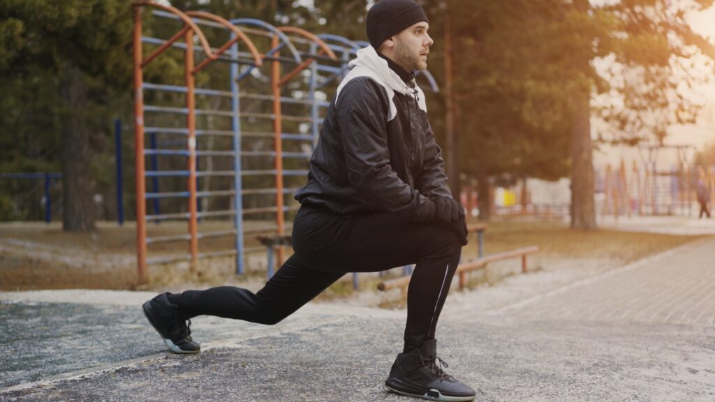 Runner doing a stretching exercise, athletic recovery